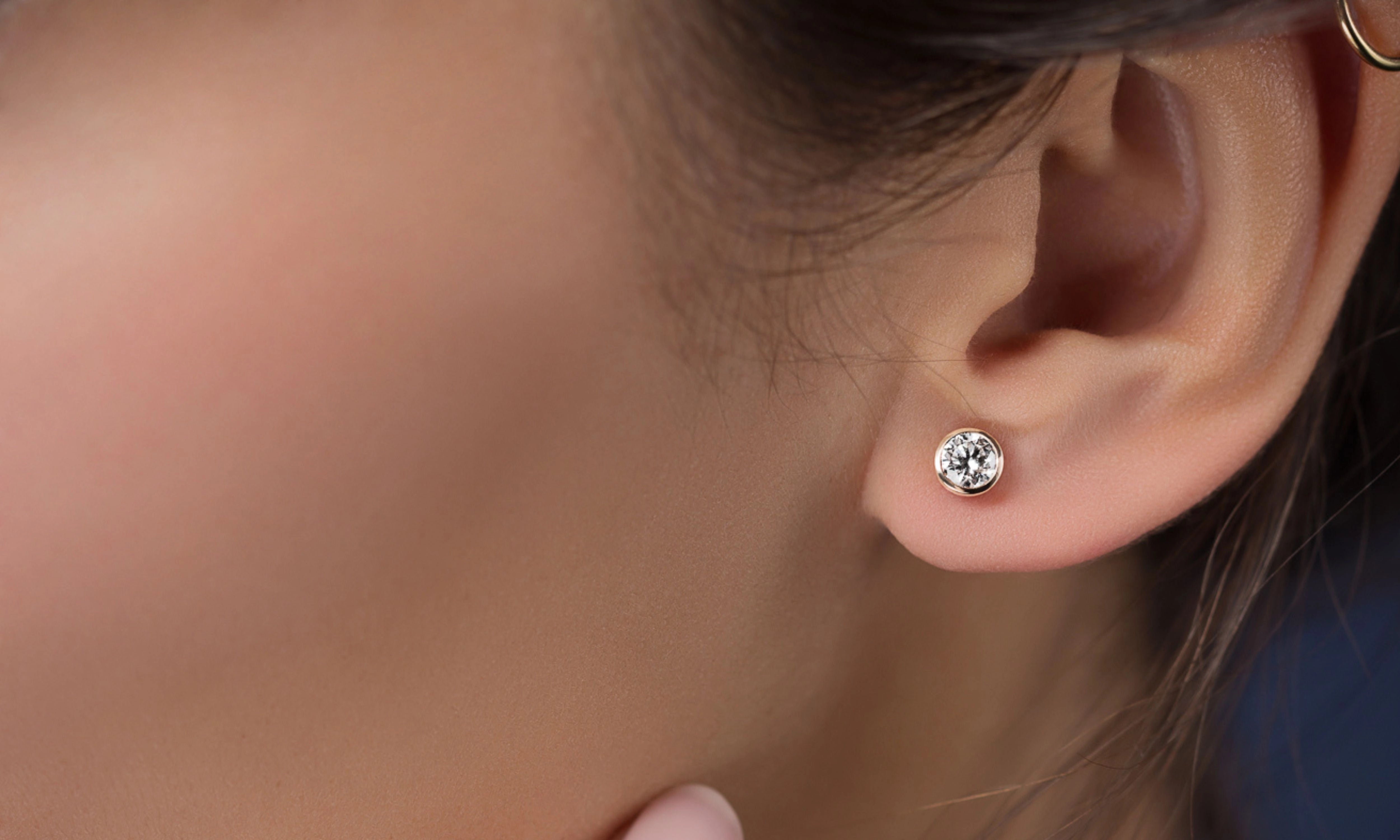 Photo d'une femme avec une boucle d'oreille en or blanc centre rond diamant